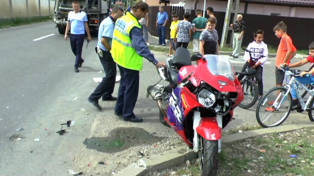 Un motociclist care staționa, acroșat de brațul de calare a unei autoutilitare (FOTO)